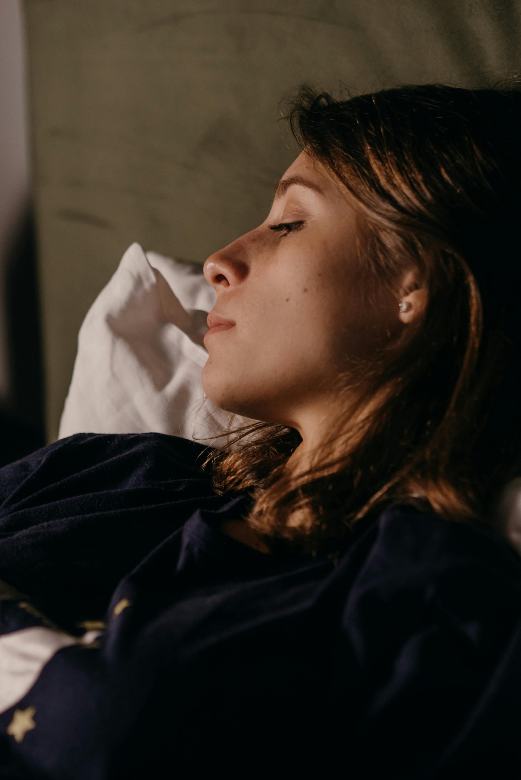 A serene portrait of a woman resting indoors, capturing a moment of tranquility and relaxation.
